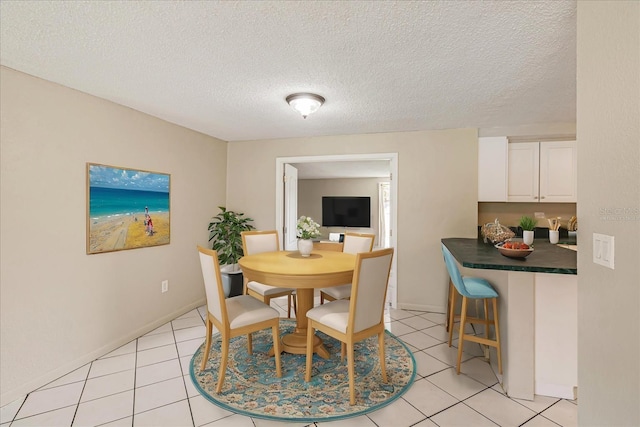 tiled dining room with a textured ceiling