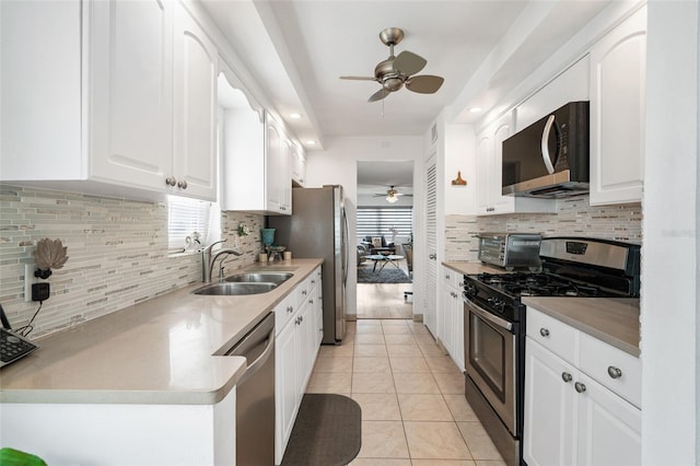 kitchen featuring white cabinets, ceiling fan, appliances with stainless steel finishes, and sink