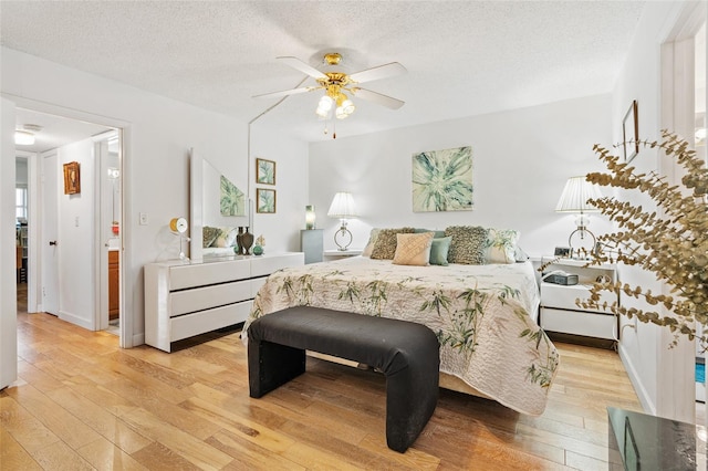 bedroom featuring ceiling fan, a textured ceiling, and light hardwood / wood-style flooring