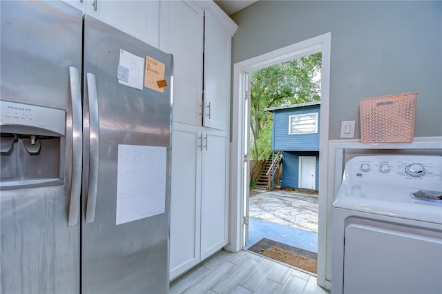 kitchen with light hardwood / wood-style flooring, washer / dryer, white cabinetry, and stainless steel refrigerator with ice dispenser