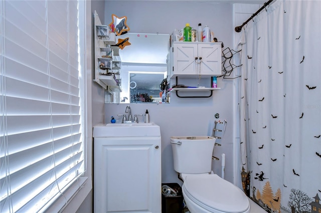 bathroom with a shower with shower curtain, toilet, and vanity