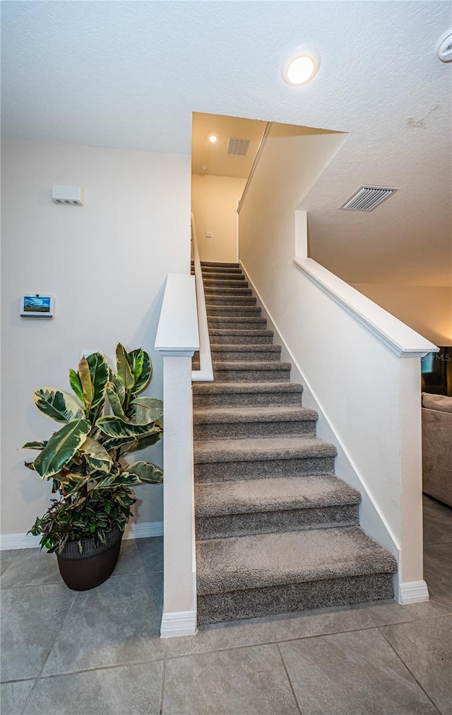 staircase with a textured ceiling