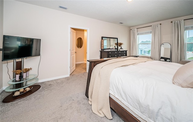 bedroom with light carpet and a textured ceiling