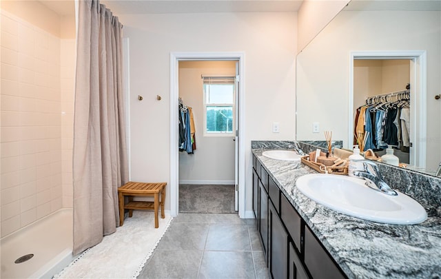 bathroom featuring tile patterned floors, walk in shower, and vanity