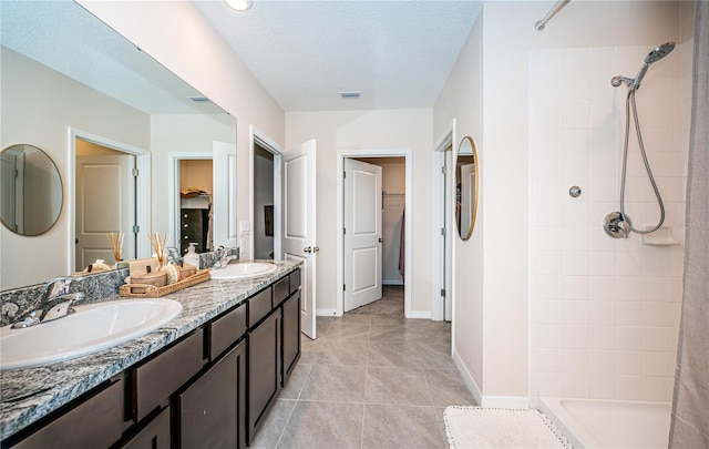 bathroom with a textured ceiling, vanity, a shower with shower curtain, and tile patterned floors