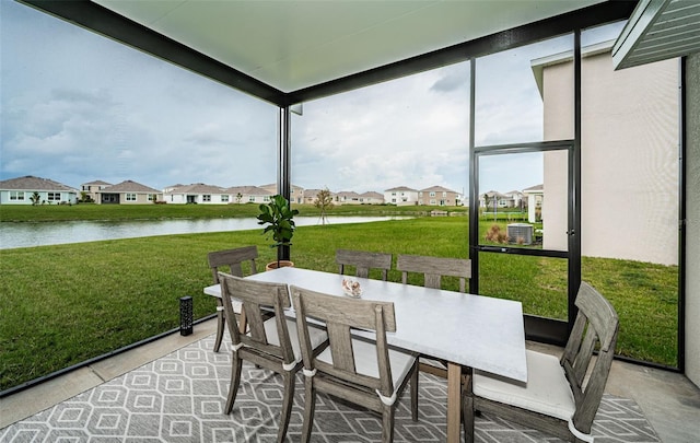 sunroom featuring a water view and a healthy amount of sunlight