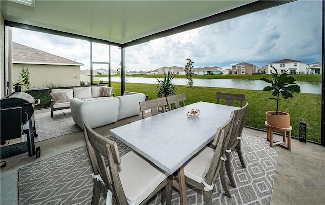 sunroom featuring a water view