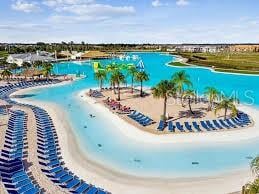 view of pool with a water view and a beach view