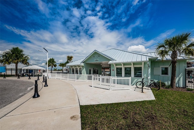 8367 Ender Hills Dr, Wesley Chapel, FL 33545 - view of front of home with board and batten siding, metal roof, a standing seam roof, and a patio area