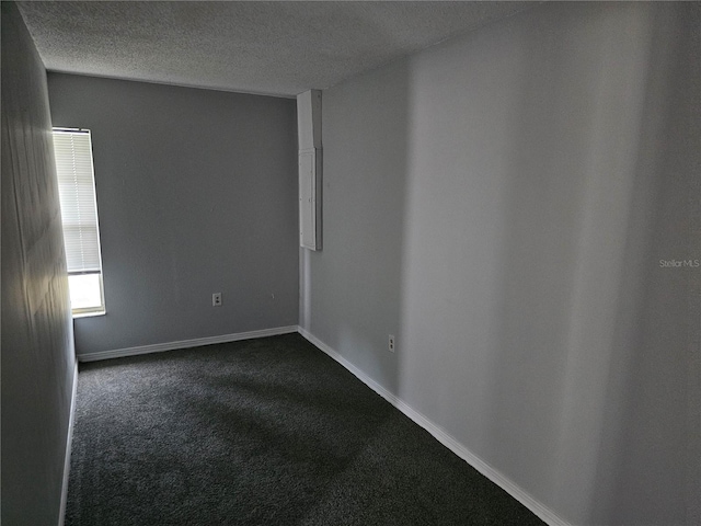 spare room with a textured ceiling and carpet