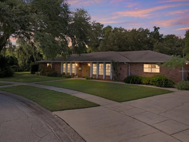 ranch-style house featuring a lawn