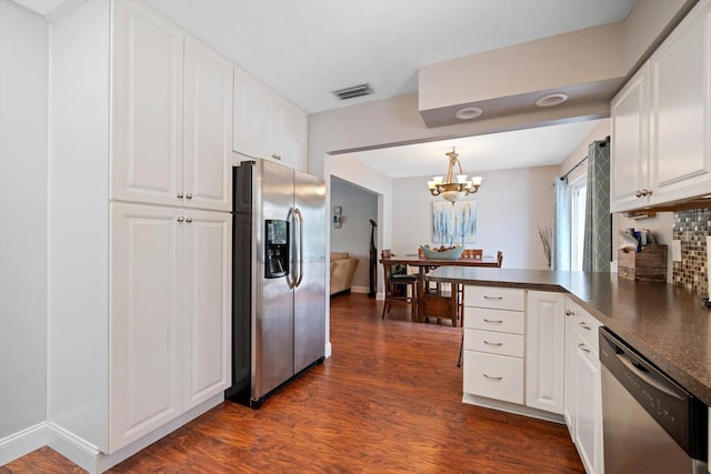 8212 Forest Cir, Seminole, FL 33776 - kitchen featuring appliances with stainless steel finishes, dark countertops, dark wood-style flooring, white cabinets, and a chandelier