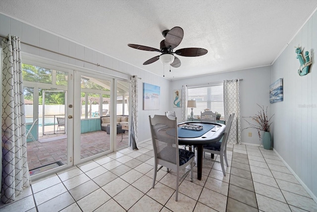 8212 Forest Cir, Seminole, FL 33776 - dining area with crown molding, a ceiling fan, a textured ceiling, light tile patterned floors, and french doors