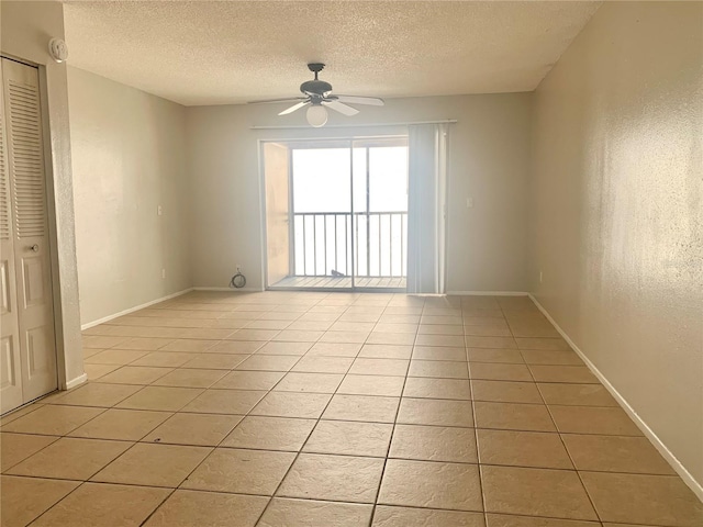 unfurnished room featuring a textured ceiling, ceiling fan, and light tile patterned floors