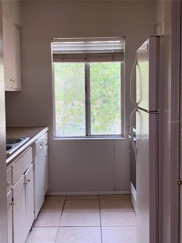 kitchen with white cabinetry, plenty of natural light, and white appliances