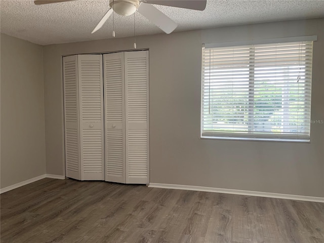 unfurnished bedroom with hardwood / wood-style floors, a textured ceiling, a closet, and ceiling fan