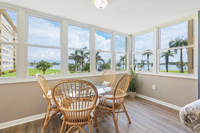 sunroom / solarium featuring a healthy amount of sunlight and a water view