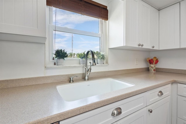 kitchen featuring sink and white cabinetry