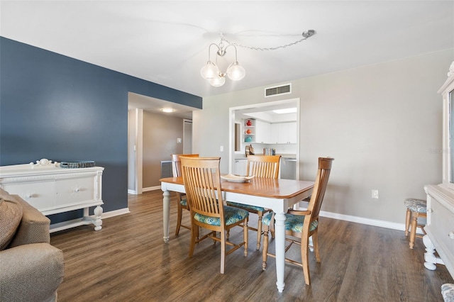 dining space with a chandelier and dark hardwood / wood-style flooring