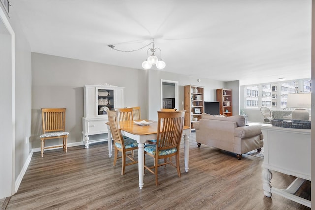 dining room with dark hardwood / wood-style flooring and a notable chandelier