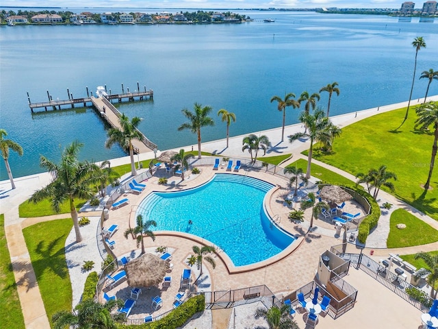 view of swimming pool featuring a patio area, a boat dock, and a water view