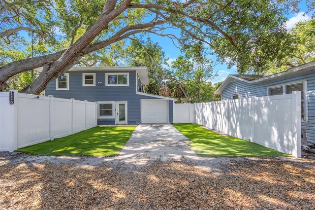7331/2 New Jersey St, Clearwater, FL 33756 - rear view of house with a garage, a lawn, a fenced backyard, and driveway