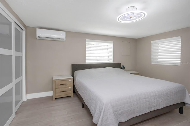 7331/2 New Jersey St, Clearwater, FL 33756 - bedroom with baseboards, a wall mounted AC, and light wood finished floors