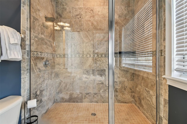 bathroom featuring walk in shower and toilet