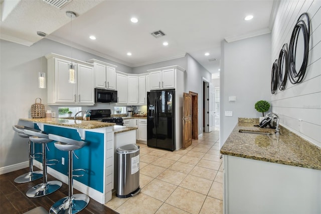 kitchen featuring white cabinets, black appliances, and kitchen peninsula