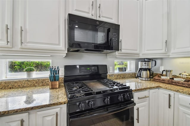 kitchen featuring white cabinets, black appliances, light stone counters, and a healthy amount of sunlight