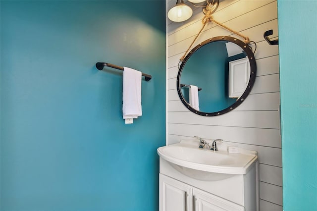 bathroom featuring wood walls and vanity