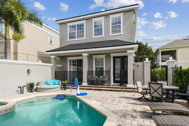 back of house with a fenced in pool and a patio area