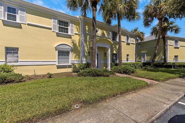 view of front of property with stucco siding and a front lawn