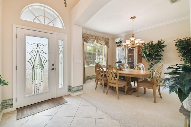 entrance foyer featuring ornamental molding, a notable chandelier, and light carpet