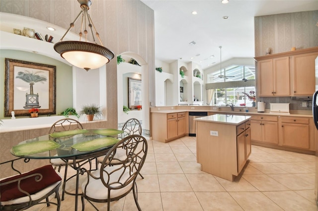 kitchen featuring light brown cabinetry, a center island, sink, pendant lighting, and stainless steel dishwasher