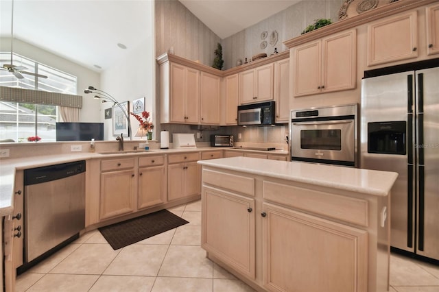 kitchen with appliances with stainless steel finishes, light tile patterned floors, light brown cabinets, and sink