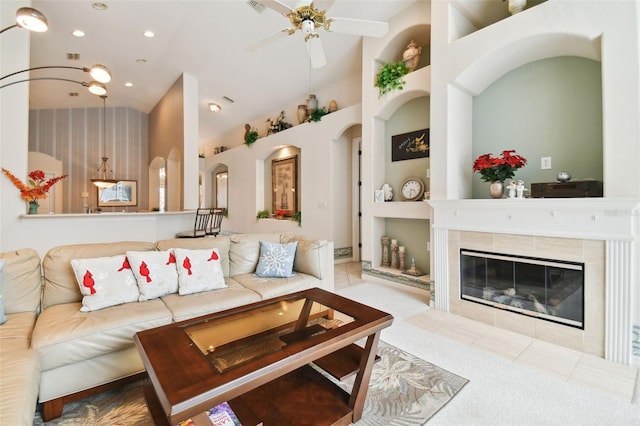 living room featuring built in shelves, ceiling fan, light tile patterned flooring, and a fireplace