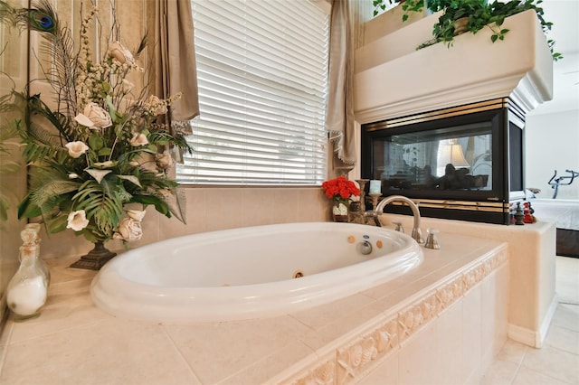 bathroom with a wealth of natural light, tiled tub, and tile patterned floors