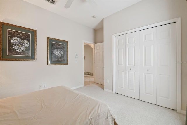 unfurnished bedroom featuring light colored carpet, ceiling fan, and a closet