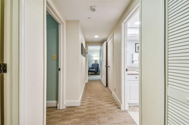 hallway featuring light colored carpet