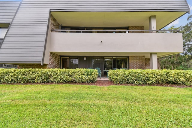 back of house with a lawn and a balcony