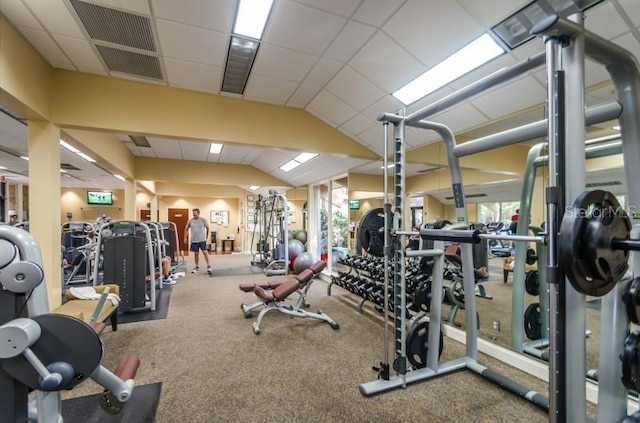 workout area featuring a drop ceiling, vaulted ceiling, plenty of natural light, and carpet flooring