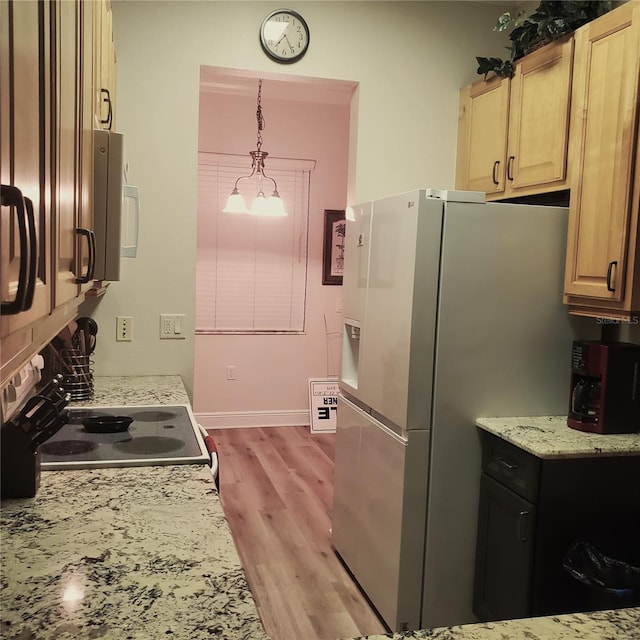 kitchen featuring backsplash, decorative light fixtures, light brown cabinetry, appliances with stainless steel finishes, and light hardwood / wood-style floors