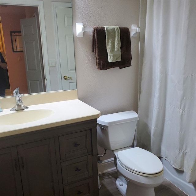 full bathroom featuring shower / bath combo with shower curtain, toilet, and vanity