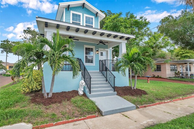 view of front of house featuring ceiling fan, a porch, and a front lawn