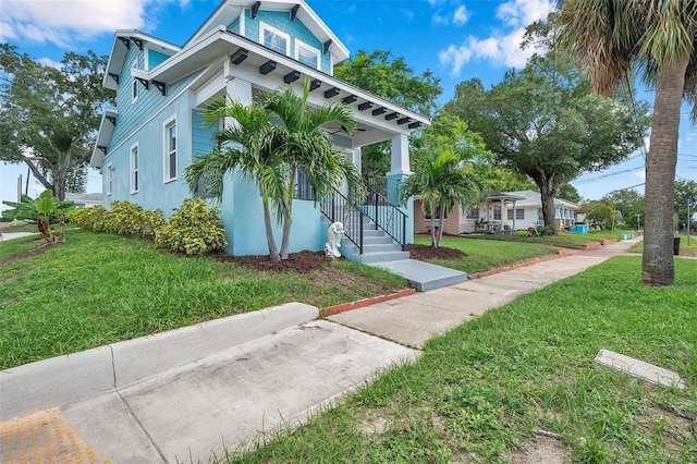 view of home's exterior with a lawn and a porch