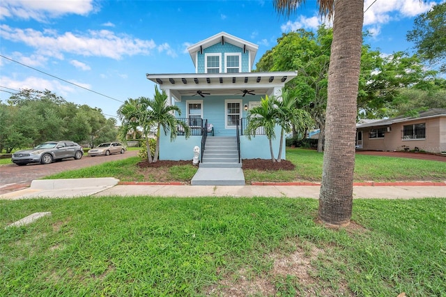 view of front facade with covered porch, a front yard, and ceiling fan