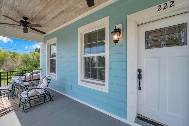 view of exterior entry with ceiling fan and covered porch