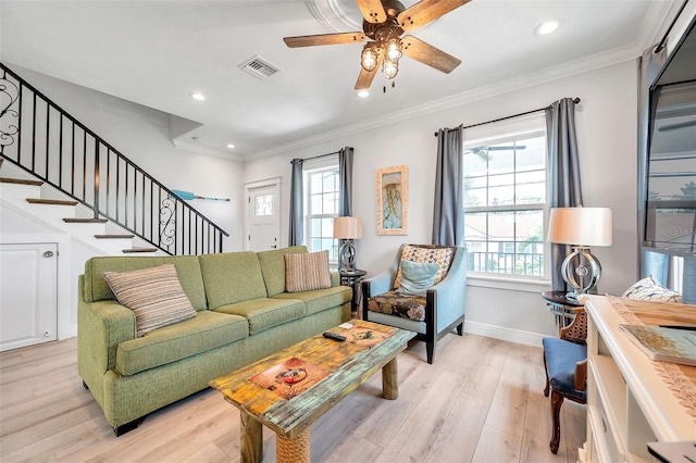 living room with light hardwood / wood-style floors, ceiling fan, and crown molding