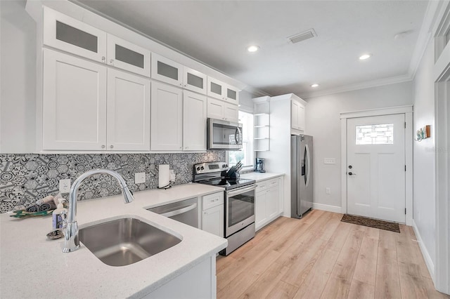 kitchen with sink, stainless steel appliances, light hardwood / wood-style floors, and white cabinetry